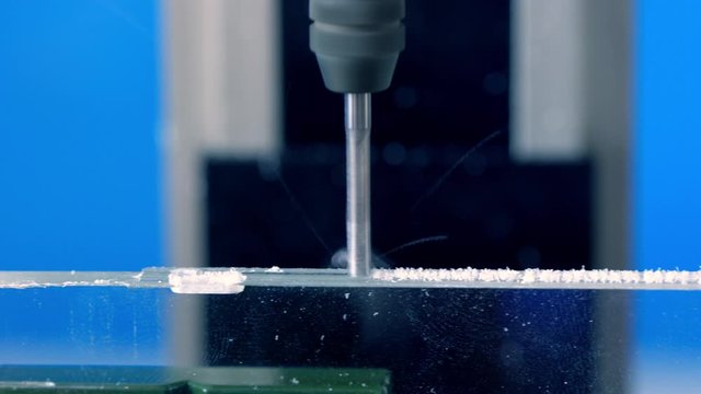 CNC milling machine processes plexiglass plastic part