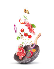 Cooking concept. Vegetables and meat are falling on a pan isolated on white background. Healthy...