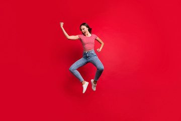 Full length body size photo of brunette stylish casual trendy girlfriend moving fast wearing jeans denim striped t-shirt footwear while isolated over red background