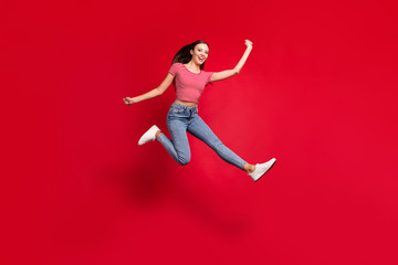 Fototapeta na wymiar Full length body size photo of beautiful attractive ecstatic girlfriend hurrying towards mall excited while isolated with red background wearing jeans denim striped t-shirt