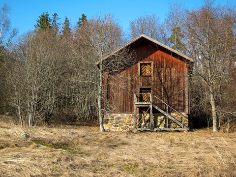An old granary made of logs and painted with red ochre paint on a beautiful spring day, Kaarina, Finland, Europe.