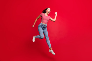 Full length body size photo of excited funky funny overjoyed rejoicing girlfriend running for sell out wearing jeans denim striped t-shirt while isolated with red background