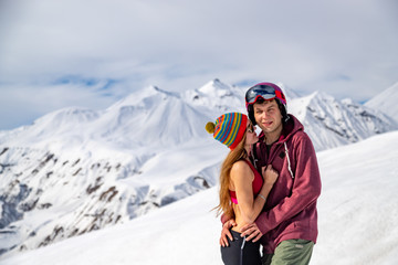 Young happy couple in snowy mountains. Winter sport vacation