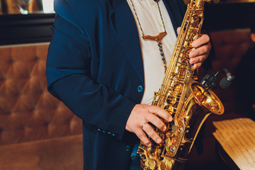 Fototapeta na wymiar Saxophone classical music instrument Saxophonist with alto sax closeup on black.