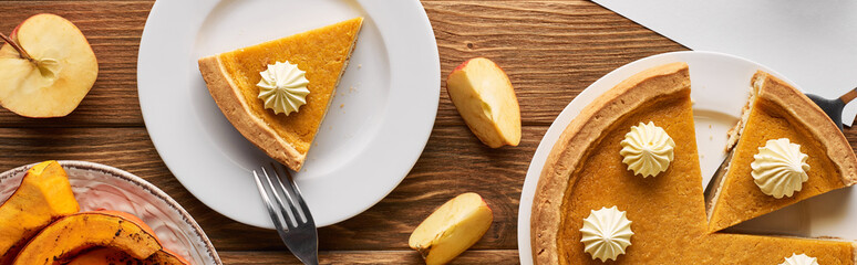 top view of delicious pumpkin pie, apples on wooden table, panoramic shot