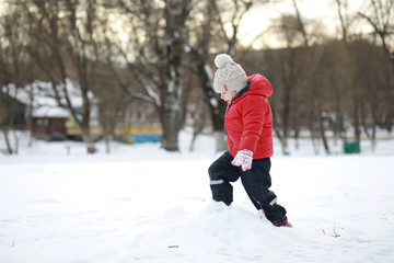 Fototapeta na wymiar Children play outside in the winter. Snow games on street.