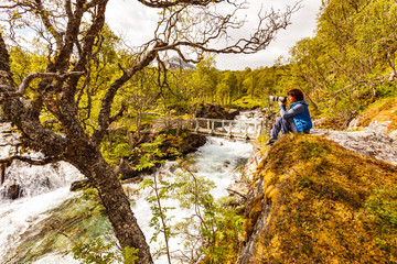 Fototapeta premium Tourist with camera at river, Norway