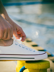 Woman tying shoes, white sneakers