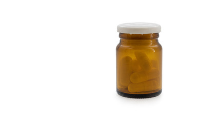 Small brown glass bottle with antibiotic pills isolated on a white background