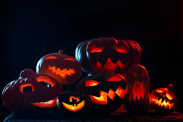 Photo of halloween pumpkins with burning mouths on blank black background.