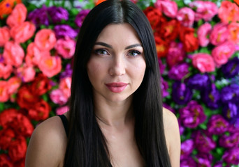 Naklejka premium Close-up Portrait of a pretty girl with good makeup brunette with long hair on a colored background. Great makeup, beautiful face.