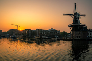 Fototapeta na wymiar Sunrise over a canal at a windmill in the Netherlands Amsterdam