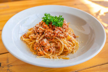 Closeup photo of spaghetti topped with parsley on white plate