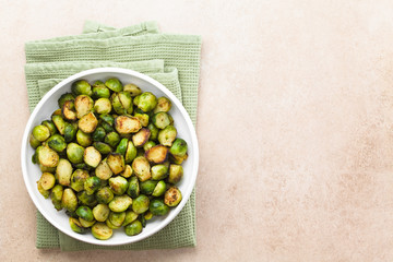 Fresh homemade roasted Brussels sprouts in bowl, photographed overhead with copy space on the right...