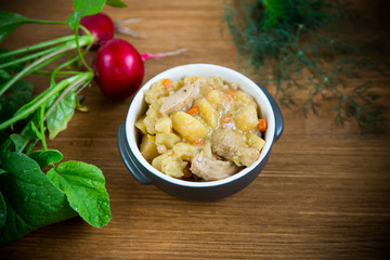stewed potatoes with vegetables, cabbage and meat in a bowl