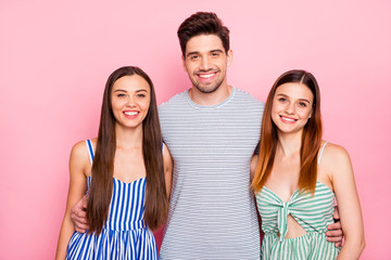 Portrait of lovely one guy two girls looking with toothy smile wearing striped dress skirt striped t-shirt isolated over pink background