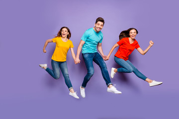 Fototapeta na wymiar Full length body size photo of having wild mad good mood group of funny millenial person hipsters hurrying to get low seasonal sales isolated violet purple background