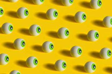 Eyes pattern on yellow background. Minimal Halloween holiday concept.