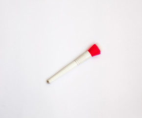 Makeup brushes and cosmetics on a white background