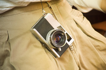 Vintage film camera with khaki trousers.