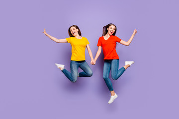 Fototapeta na wymiar Full body size length photo of two charming beautiful careless fascinating nice optimistic glad ladies flying up in air isolated violet background