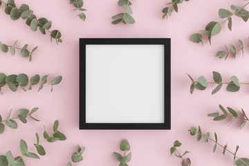 Top view of a black square frame mockup surrounded by branches of eucalyptus on a pink background.