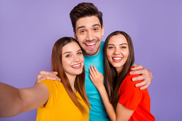 Close-up photo portrait of cheerful positive two ladies and one handsome glad funky careless glad boy with modern hairstyle having fun isolated violet background