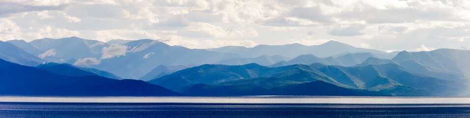 Landscape with lake and mountains in cloudy weather. Panorama of Baikal Lake