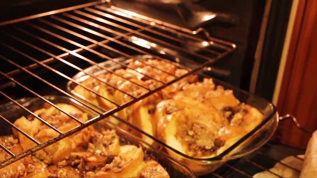 Taking baked french toast out of the hot oven with pot holders