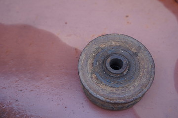 Old rusted hoist on a metal plate