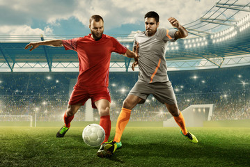 Two professional soccer players fight for the ball during the match