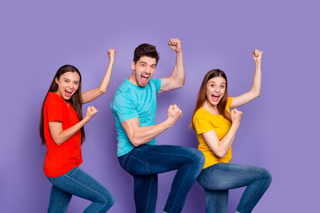 Profile side view portrait of nice attractive lovely content cheerful cheery overjoyed guys wearing colorful t-shirts jeans having fun cool attainment isolated over violet lilac background