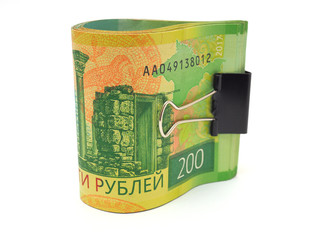A rolled up bundle of Russian banknotes with a face value of two hundred rubles is on a white background. Not isolated. Saturation and contrast are enhanced. Close-up
