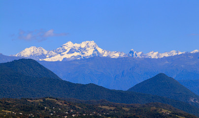 Beautiful view of snow-covered and green mountains of Abkhazia in autumn.