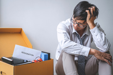 Images of packing up all his personal belongings and files into a brown cardboard box, Businessman...