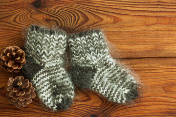 Fototapeta na wymiar Hygge flatlay. Woolen socks on a wooden background top view with copy space.