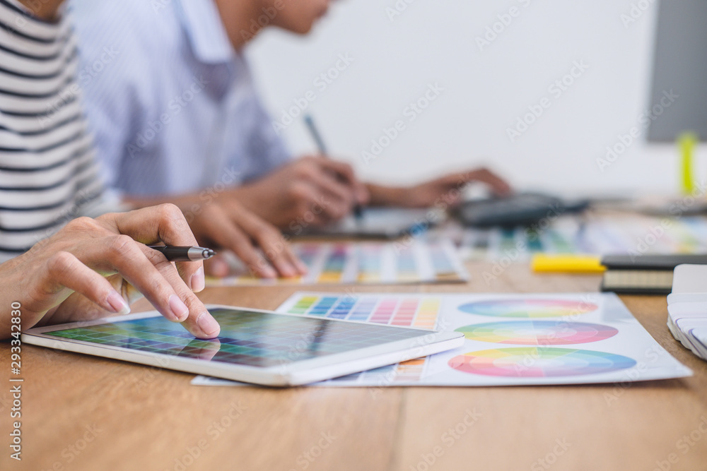 Poster Two colleagues creative graphic designer working on color selection and drawing on graphics tablet at workplace, Color swatch samples chart for selection coloring