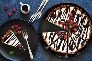 Homemade vanilla cheesecake with chocolate sauce and berries on a concrete background. View from above.