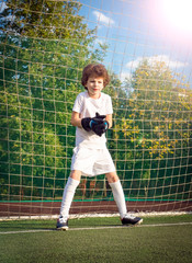 Summer soccer tournament for young kids. football club. emotions and joy of the game. Young goalie. Kids - soccer champion. Boy goalkeeper in football sportswear on stadium with ball. Sport concept.