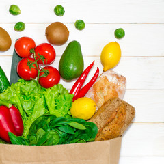 Paper bag of different health food on white wooden background. Top view. Flat lay