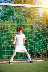 Summer soccer tournament for young kids. football club. emotions and joy of the game. Young goalie. Kids - soccer champion. Boy goalkeeper in football sportswear on stadium with ball. Sport concept.