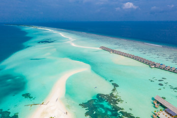 Fototapeta na wymiar Aerial view of water bungalow and blue sea sky background in Maldives. Luxury summer vacation background, exotic travel concept