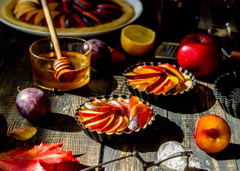 Cooking plum apple pie. Raw pie. Dough. Recipes. Vegetarian food. Dark photo.