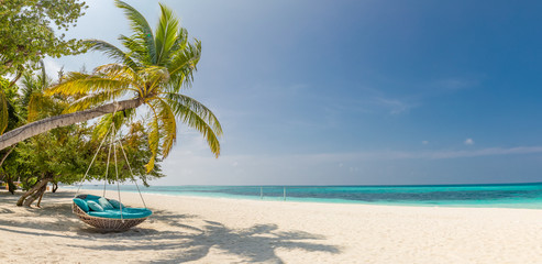 Tropisches Strandpanorama als Sommerlandschaft mit Strandschaukel oder Hängematte und weißem Sand und ruhigem Meer für Strandbanner. Perfektes Strandszenen- und Sommerferienkonzept. Beschleunigen Sie den Farbprozess