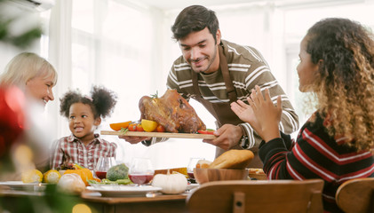 father carrying turkey served for family on thanksgiving dinner .Thanksgiving Celebration tradition...