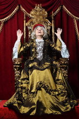 Portrait of happy beautiful senior queen on throne