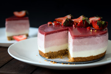 Delicious no bake strawberry layers cheesecake served on white plate