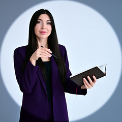 Portrait of a pretty brunette girl with long hair manager in a dark business suit in a circle of...