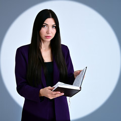 Portrait of a pretty brunette girl with long hair manager in a dark business suit in a circle of...