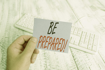 Text sign showing Be Prepared. Business photo showcasing try be always ready to do or deal with something man holding colorful reminder square shaped paper white keyboard wood floor